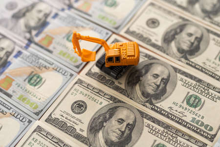 one hundred dollar bills and a toy excavatorの写真素材