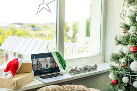 A happy family with a child is celebrating Christmas with their friends on video call using webcam....