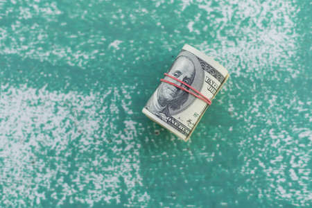 Money is twisted. Cash USA dollars. Franklin portrait. Hundred dollar banknotesの写真素材