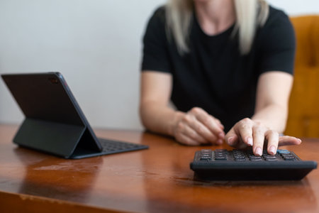 Lets check my timetable. Cheerful young beautiful woman using her touchpad with smile while sitting...