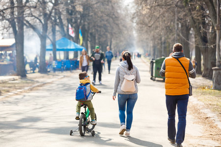 Boy learning to ride a bicycle with his father in park. parents teaching his son cycling at park.の写真素材