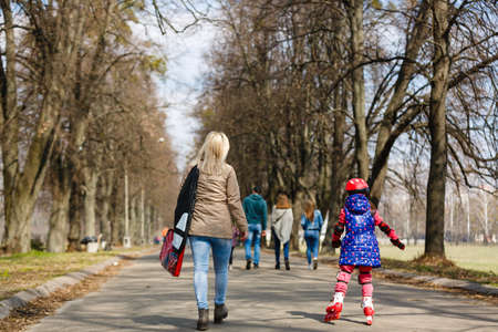 Mother and her daughter wearing roller skates in parkの写真素材