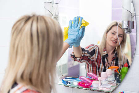 Woman cleaning and polishing with a spray detergent, housekeeping and hygiene conceptの写真素材