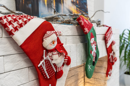 Christmas socks for Santa Claus gifts hang over the fireplace in the house.