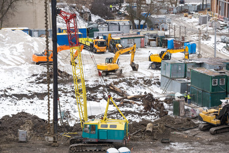 aerial top view of city construction site. tower cranes for building of new apartments under snow in...