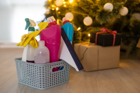 Cleaning before Christmas. Multicolored cleaning supplies. Sponges, rags and spray with festive...