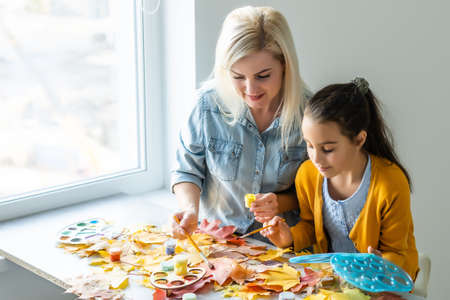 mother and daughter paint autumn leavesの写真素材