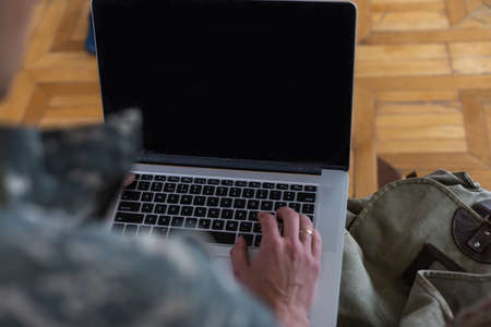 soldier in military uniform using high tech computer in headquarters intelligence centerの写真素材