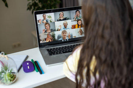 Home schooling. A girl is sitting at a table with a laptop during an online video chat of a school...