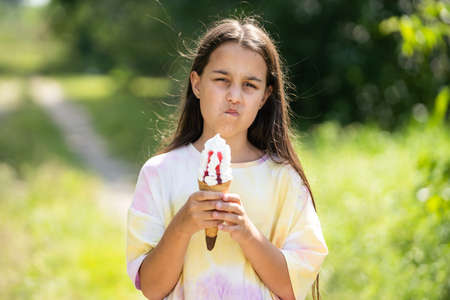 Beautiful child girl holding ice cream with angry face, negativeの写真素材