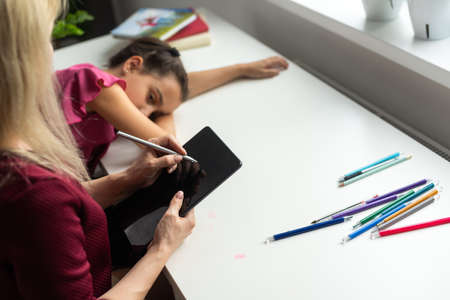 Female psychologist working with little girl at homeの写真素材