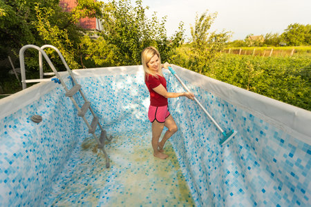 woman cleaning the pool in the garden