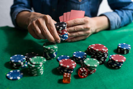 woman hand on green poker table with chipsの写真素材