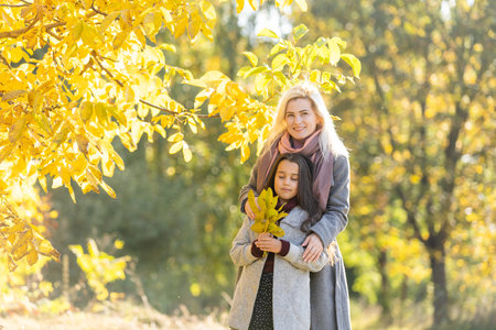 mother with her daughter in autumnal alley
