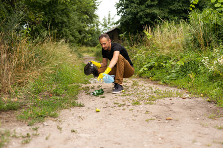 Young volunteer picking up plastic bottles in the park