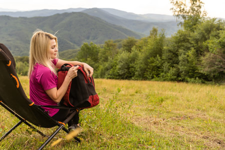 Tired middle age woman resting after hiking in natureの写真素材