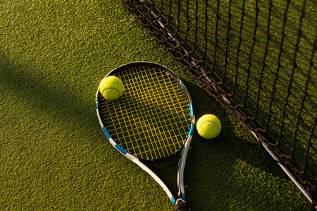 tennis balls and racket on the green grass background