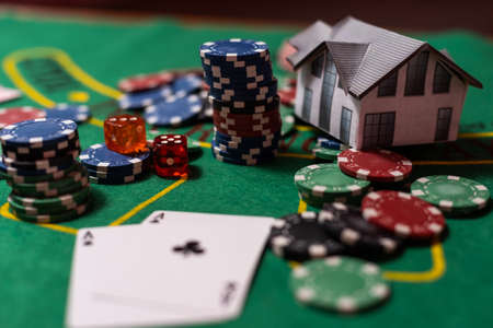 poker chips, money, toy house on blackjack tableの写真素材