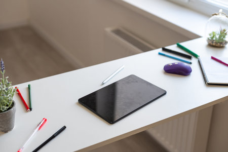 tablet putting on wooden working desk with pencil and pen