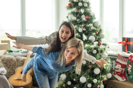 Mother with adult daughter, christmas tree