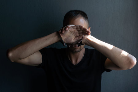 male hands in handcuffs black background
