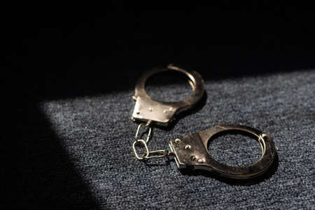 the black handcuffs on wooden background. criminal justiceの写真素材