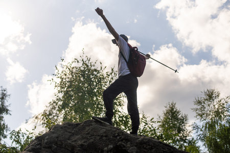 man hand holding hiking pole with green bokeh background and copy space. Summer activity for...