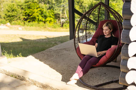 Work from home or study online, concept with a woman working at laptop outdoor on terraceの写真素材