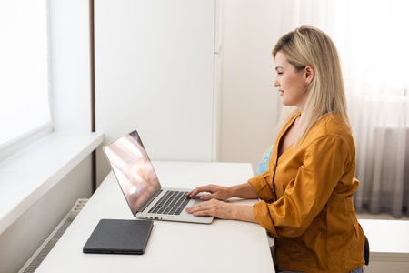 Shot of a middle aged woman using a laptop at home. Businesswoman working from home.