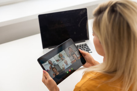 Smiling millennial woman using modern gadget, chat on tablet device, technology conceptの写真素材
