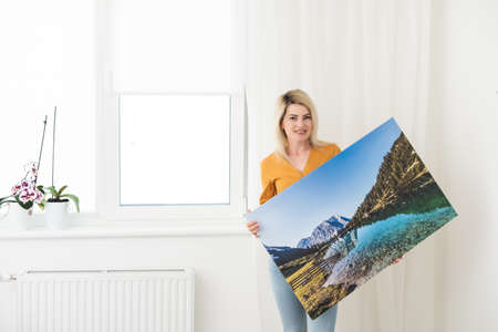 Canvas prints. woman holding photo canvasの写真素材