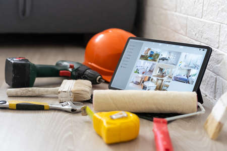 repair, diy and home improvement concept - close up of tablet pc computer and painting tools on table.の写真素材