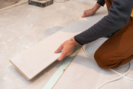carpenter worker installing laminate flooring in the room.の写真素材