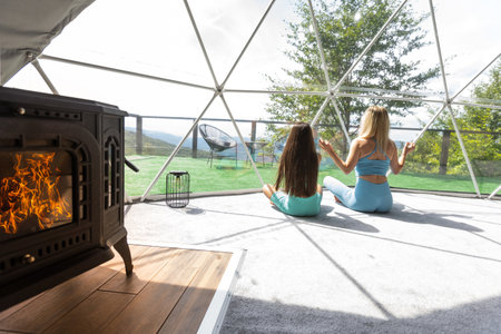 mother and daughter yoga in glamping dome tent domesticの写真素材