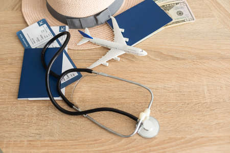 Medical Tourism, medical travel concept. Stethoscope, toy plane and passport on wooden backgroundの写真素材