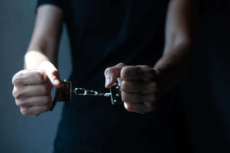 prisoner concept, Handcuffed hands of a prisoner in prison, Male prisoners were severely strained in the dark prison, violence,の写真素材