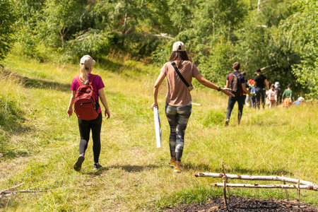 Group of friends trekking with backpacks walking in the forest.