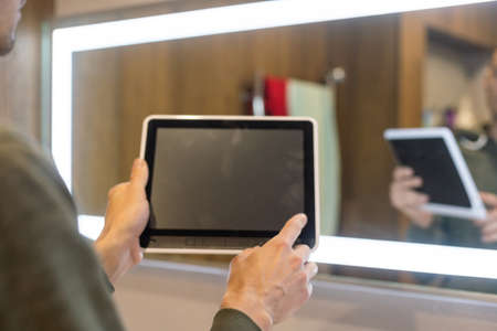 Smart home control on tablet. Interior of living room in the background.の写真素材