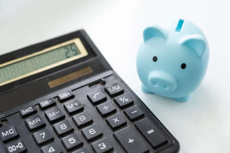 Piggy bank, calculator on white background and copy spaceの写真素材