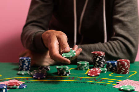 man playing blackjack at the table and betting chipsの写真素材