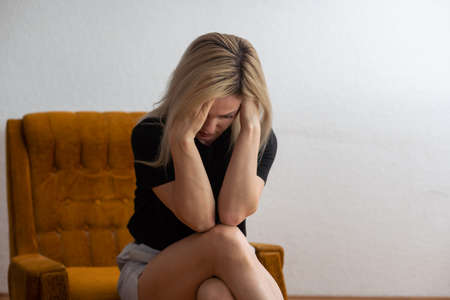 Portrait of sad upset frustrated girl, young lonely desperate woman holding her head with hand, suffering from hard life, problems or headache. Despair, depression, loneliness conceptの写真素材