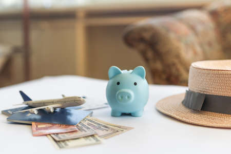 Save money for airplane tickets, planning travel budget concept. Airplane model, piggy bank on wooden tableの写真素材