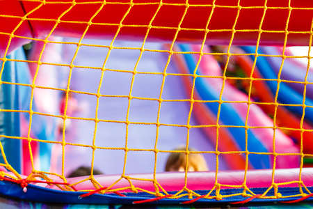 mesh on an inflatable trampoline. Active games for childrenの写真素材
