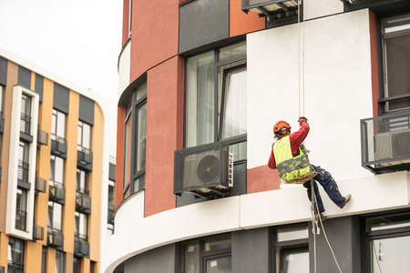 construction worker is painting a wall with a rollerの写真素材