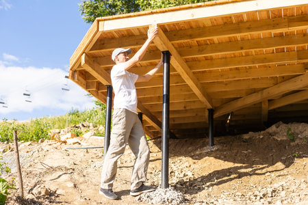 Building wooden materials next to house. Process of building wooden house. Construction of frame house. Lumber at construction site. Concept - sale of lumber for construction. Sale of lumberの写真素材