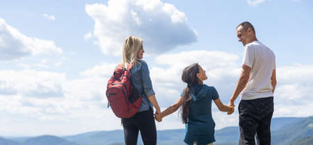 Family hiking parents with child outdoor travel in mountains active vacations lifestyle mother and father backpacking together.の写真素材