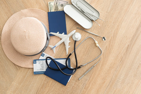 Travel and healthcare concept. Top view of passport, stethoscope and toy plane on wooden background...