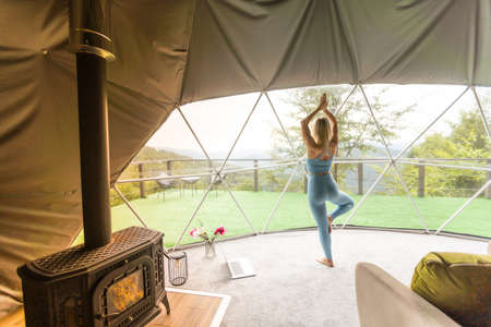 Sporty woman doing exercise in a geo dome glamping tentの写真素材