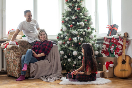 Christmas family. Happy mom, dad and little daughter. Enjoyng love hugs, holidays people. Togetherness conceptの写真素材