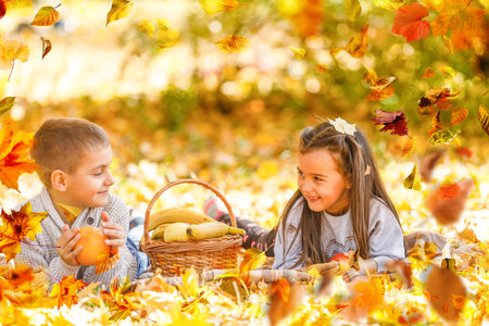 Two little cute smiling kids in bright jackets walking together in a park on a sunny autumn day. Friendship between siblings. Happy family conceptの写真素材